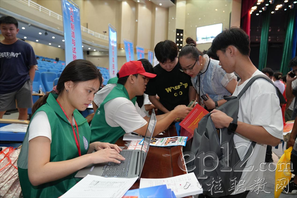 新生与家长在迎新处拍照打卡